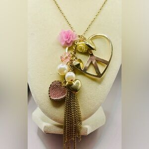 Gold tone long charm necklace with heart, faux pearls, flowers, and bead charms